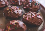 close up of chocolate iced cupcakes with sprinkles